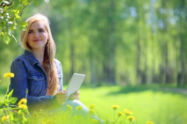 Genç kadın parkta tablet kullanma