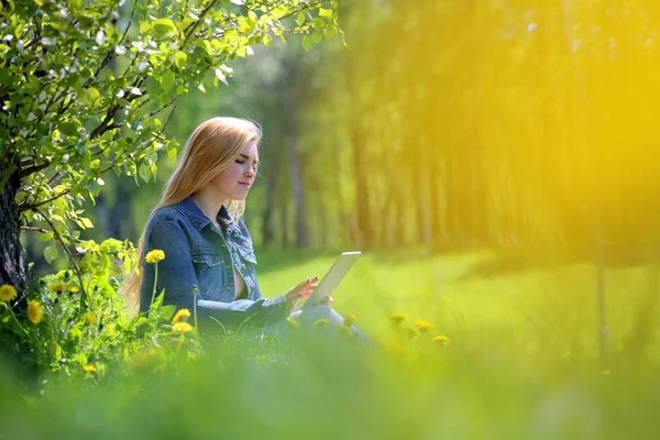 Young woman using tablet in park — Stock Photo, Image