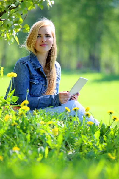 Young woman using tablet in park — Stock Photo, Image