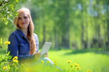 Genç kadın parkta tablet kullanma