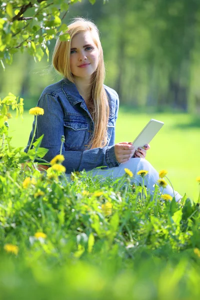 Young woman using tablet in park — Stock Photo, Image