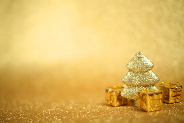 Natal árvore de abeto decorativa e caixa de presente no fundo brilho — Fotografia de Stock