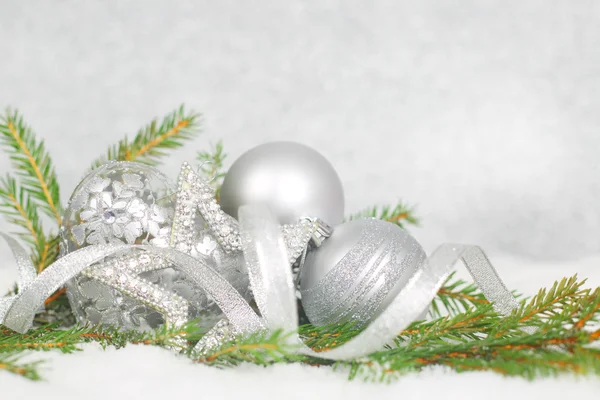 Christmas balls and green fir branch on snow — Stock Photo, Image