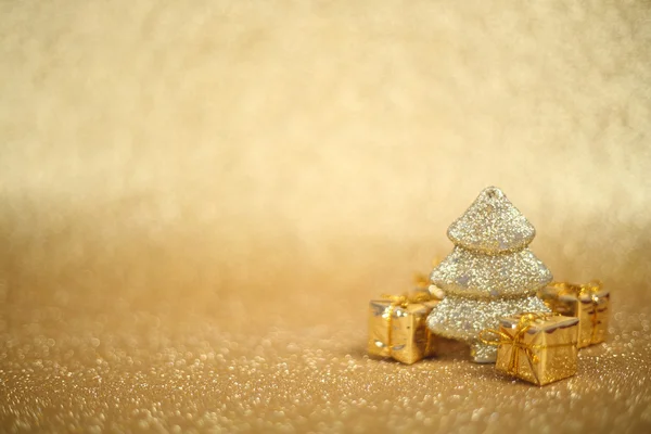 Sapin décoratif de Noël et boîte cadeau sur fond de paillettes — Photo