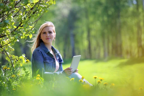 Young woman using tablet in park — Stock Photo, Image