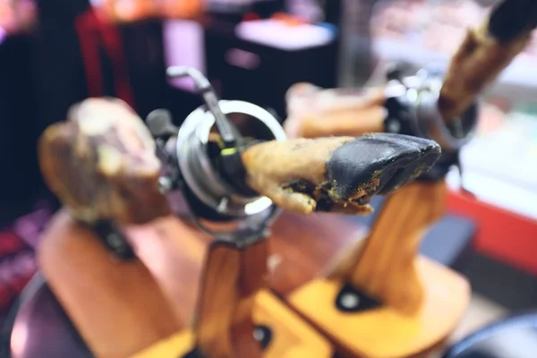 Tradicional espanhol jamon pernas na vitrine na loja — Fotografia de Stock