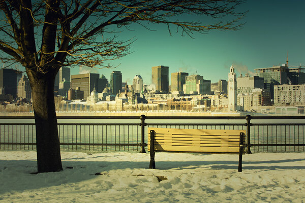 Bench in front of Montreal downtown and st-Lawrence river during winter