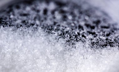 Siyah arkaplanda cam kavanozdaki kristal şekeri kapat.