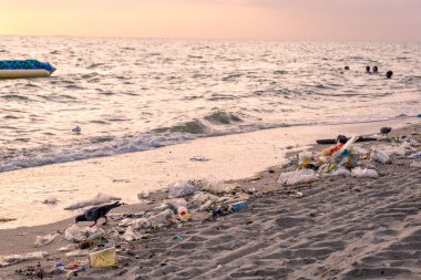 Kirli deniz kumlu kıyı, çevresel kirlilik, okyanustaki plastik su şişeleri kirliliği (Deniz enkazı)