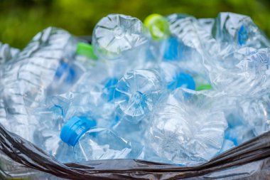 Siyah çöp torbalarındaki plastik şişeler geri dönüşüm için alınmayı bekliyor..