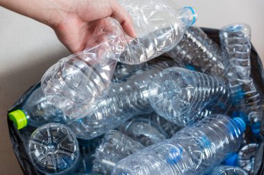 Siyah çöp torbalarındaki plastik şişeler geri dönüşüm için alınmayı bekliyor..