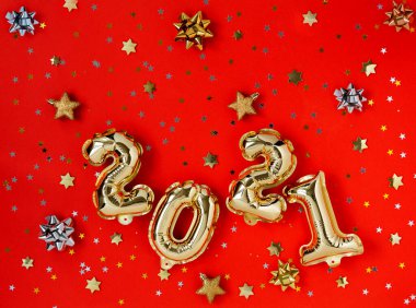 Mutlu yıllar 2021. Kırmızı zemin üzerinde 2021 numaralı altın rengi balon tatili. 