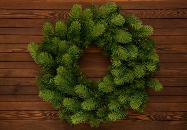 Ahşap bir arka planda yeşil Noel çelengi. Noel dekoru.