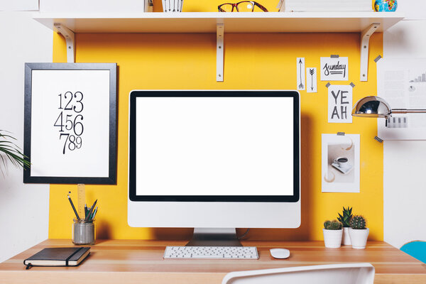 Modern creative workspace on yellow wall. 