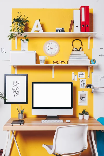 Modern creative workspace on yellow wall. — Stock Photo, Image