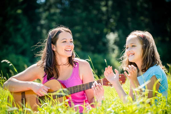 Mutter spielt Gitarre in der Natur — Stockfoto