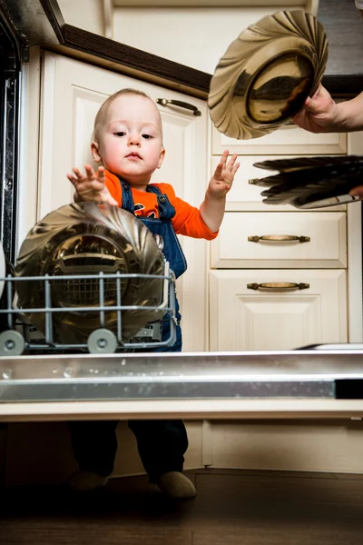 Baby hjälper lossa diskmaskin — Stockfoto