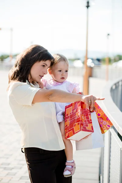 Mamma med barn med kassar och påsar — Stockfoto