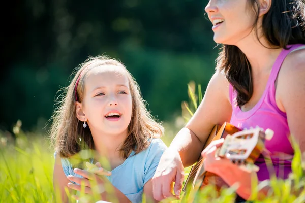 Mãe tocando guitarra na natureza — Fotografia de Stock