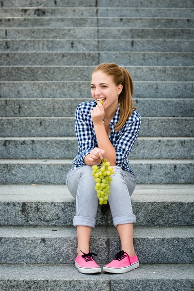 若い女性がブドウを食べ — ストック写真