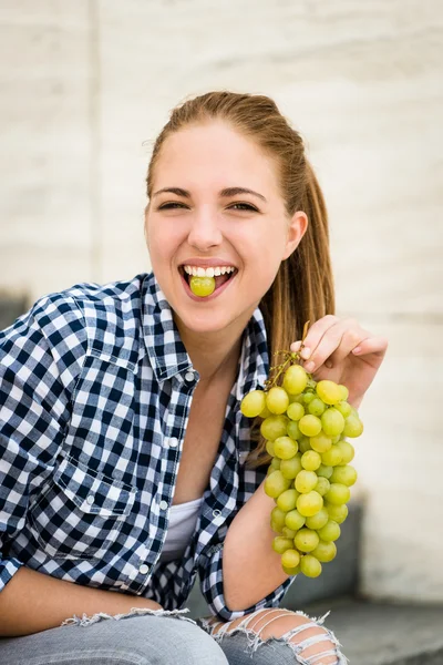 Junge Frau isst Weintrauben — Stockfoto