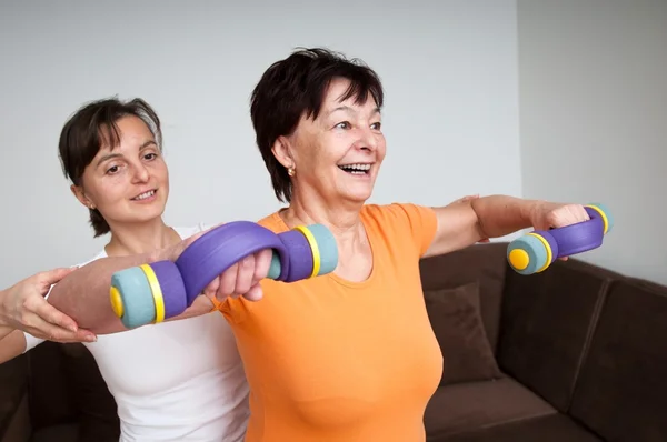 Entrenador ayudar a las mujeres mayores de ejercicio — Foto de Stock