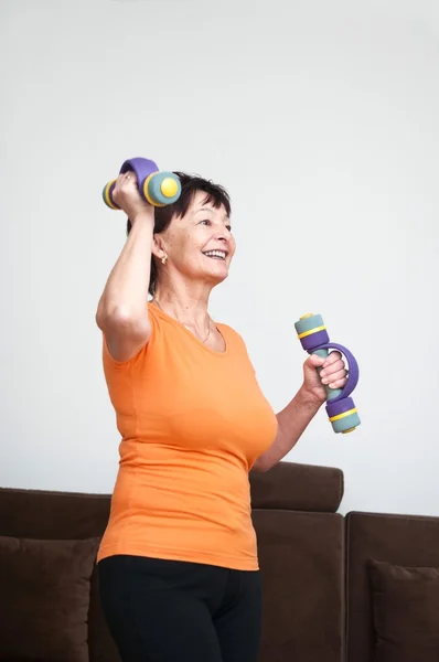 Mulher sênior exercitando com sinos — Fotografia de Stock