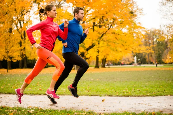 Par jogging i höstens natur — Stockfoto