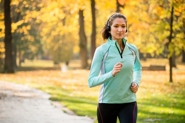 Donna che corre e ascolta musica — Foto Stock