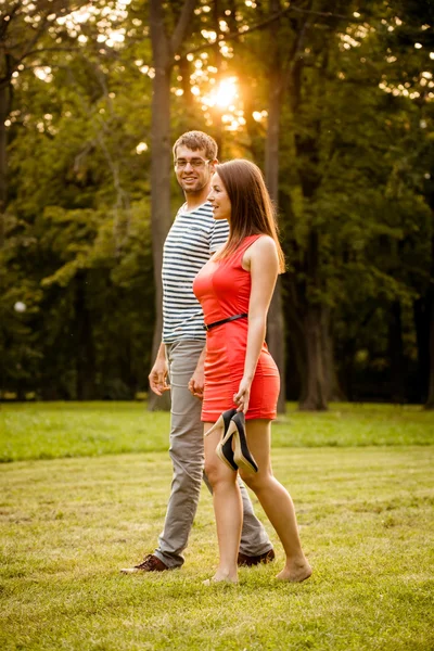 Jovem casal andando na grama — Fotografia de Stock