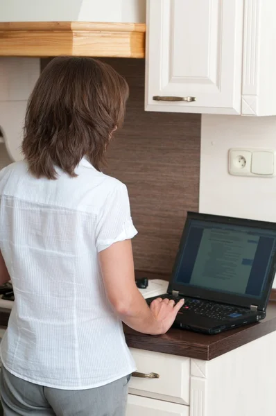 Multitasking - preparing meal and working — Stock Photo, Image