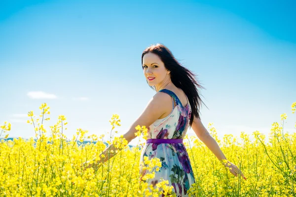 Young woman in rapeseed field — Stock Photo, Image