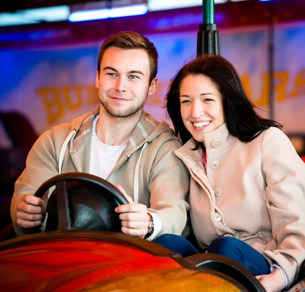 Young couple riding car in amusement park — Stock Photo, Image