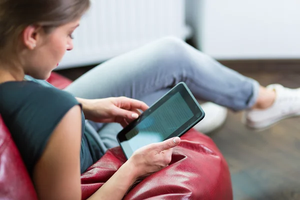 Mulher lendo um ebook em sua casa — Fotografia de Stock