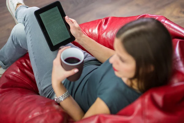 Mulher lendo um ebook em sua casa — Fotografia de Stock