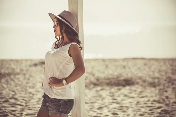 Stijlvolle vrouw aan het strand van de zomer — Stockfoto