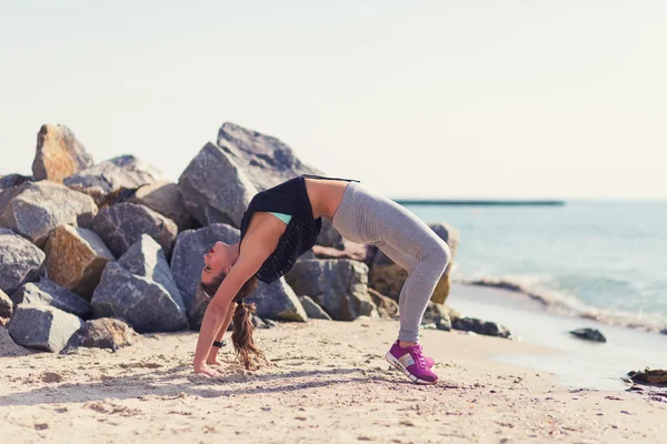 Mujer practicando yoga en la playa — Foto de Stock