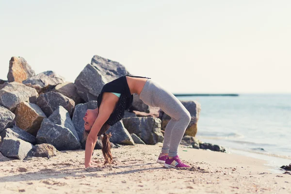 在海滩练瑜伽的女人 — 图库照片