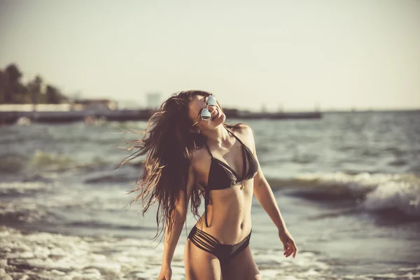 Mooie jonge vrouw het hebben van plezier op het strand — Stockfoto