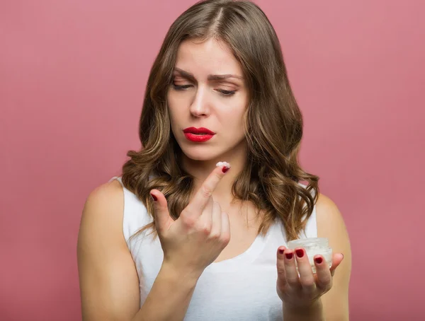 Bella donna con una crema idratante viso — Foto Stock