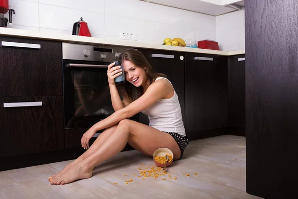 Vrouw met een ontbijt op haar keuken — Stockfoto