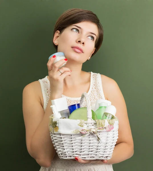 Chica con una cesta llena de productos para el cuidado de la piel — Foto de Stock