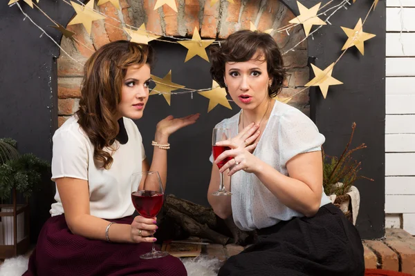 Two beautiful girl friends playing chess by the fireplace — Stock Photo, Image