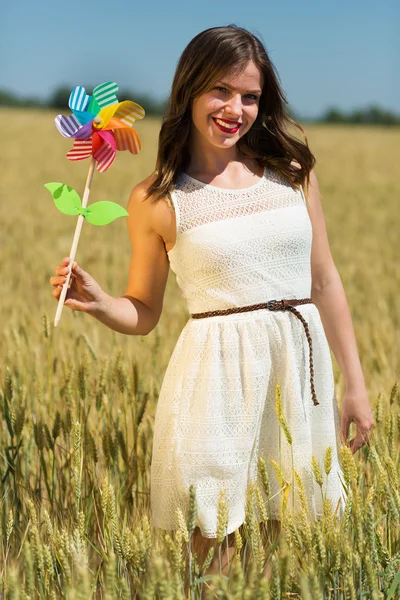Happy girl with a colorful windmill — ストック写真