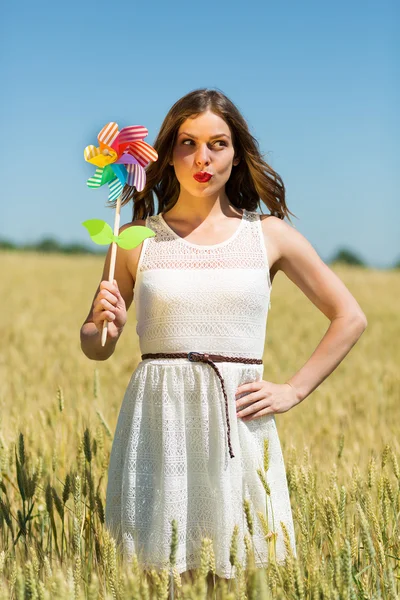 Happy girl with a colorful windmill — ストック写真