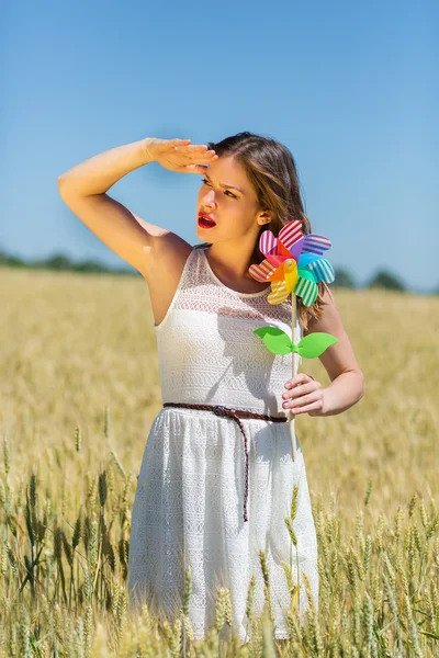Happy girl with a colorful windmill — Stockfoto