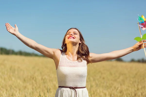 Happy girl with a colorful windmill — Stock Photo, Image