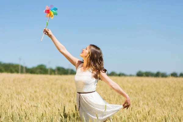 Happy girl with a colorful windmill — Stok fotoğraf