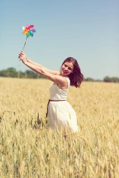 Happy girl with a colorful windmill — Stock Photo, Image