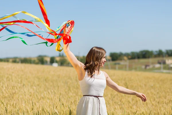 Happy girl holding colorful ribbons — Stockfoto